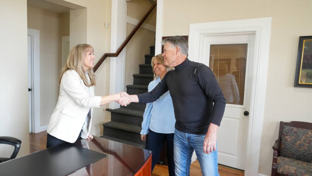 couple shakes hands with attorney's office representative for business formation